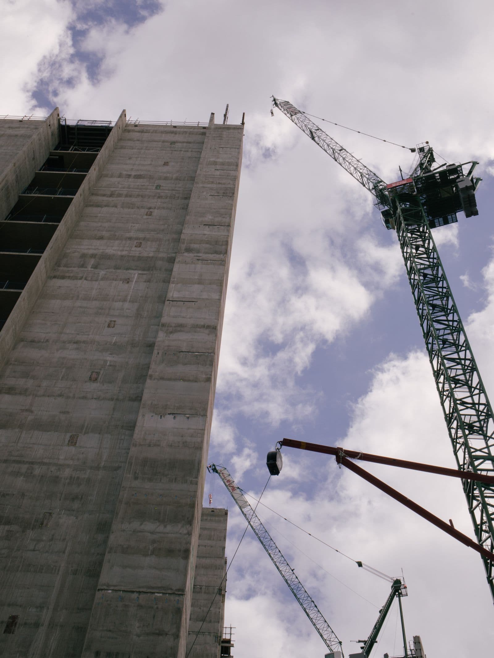 Guindaste trabalhando junto a um edifício moderno em construção