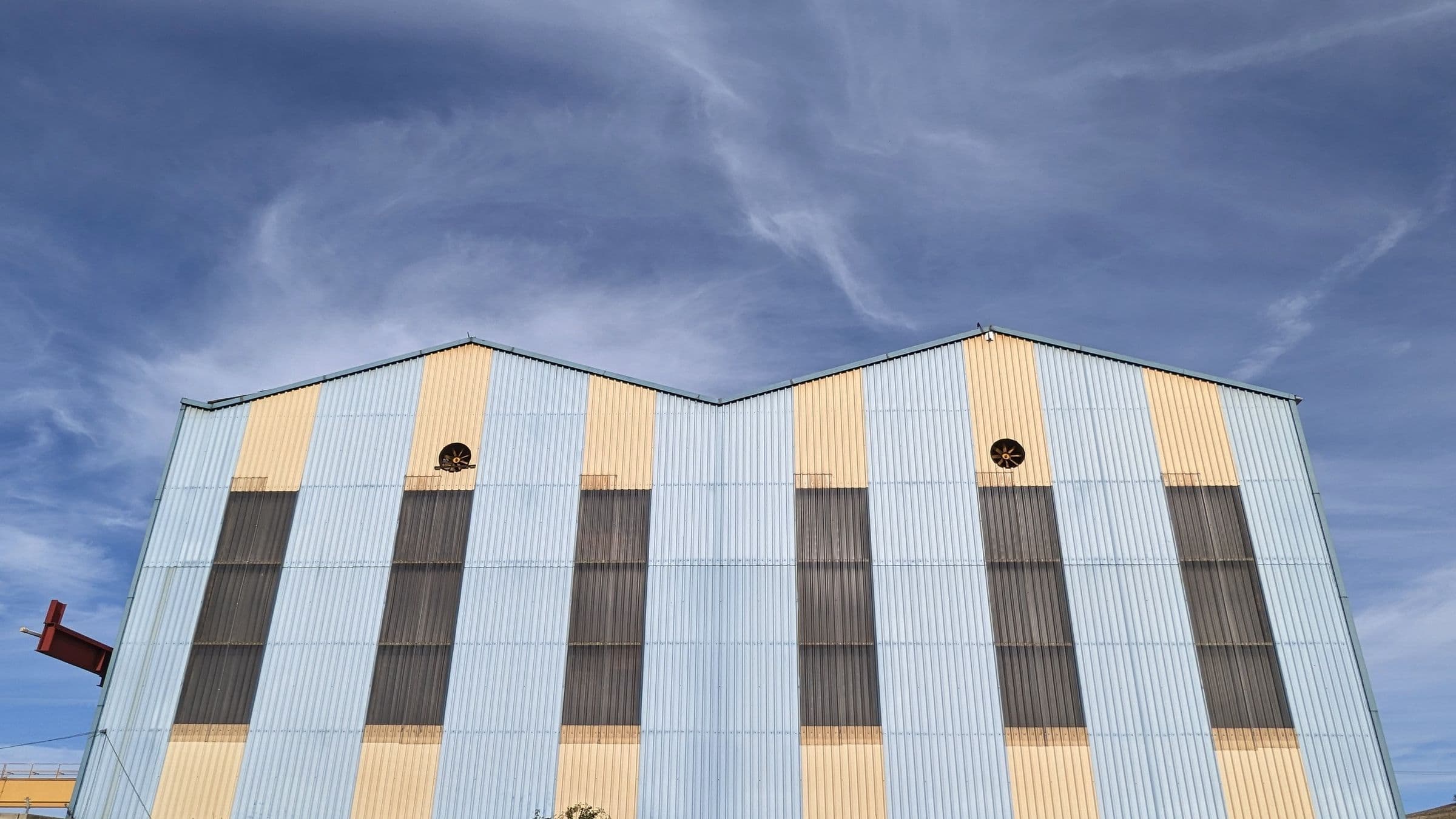 Fachada de um galpão industrial contra o céu azul